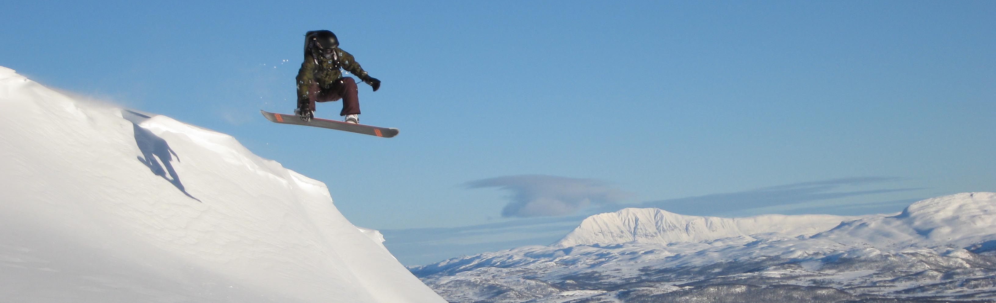 Snowboarder mot fjell og blå himmel i Rauland